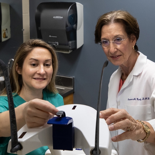Two members of School of Dentistry faculty examine equipement together